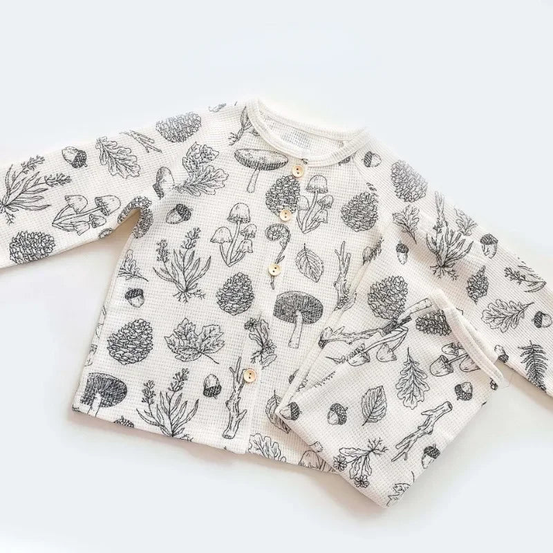 Baby pyjama set ontworpen met een speelse herfstprint en zachte stoffen.