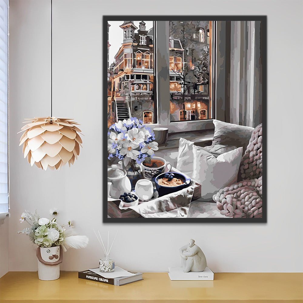 Artistiek canvas schilderij dat een gezellig interieur met stadszicht weergeeft.